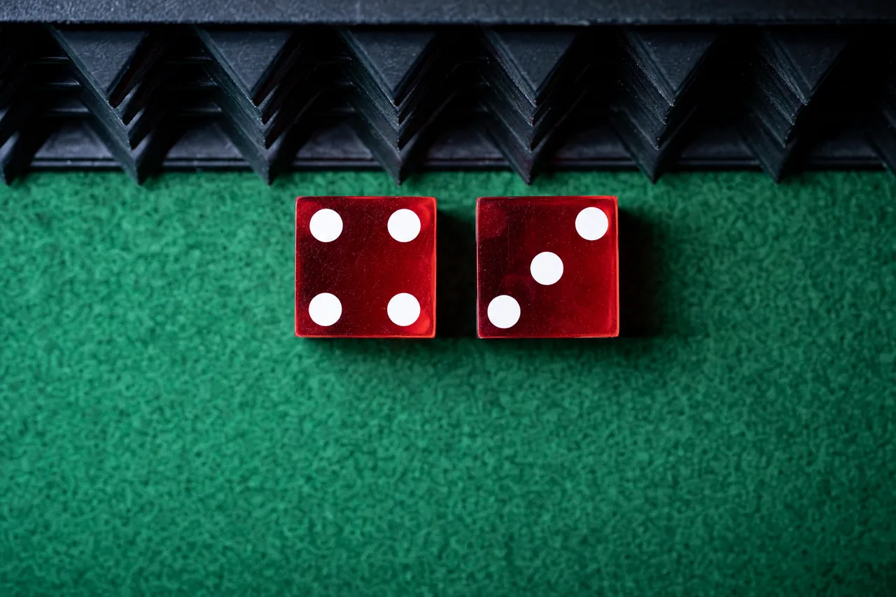 Illustration of two red dice coming to rest on green felt in front of the textured back wall of a craps table